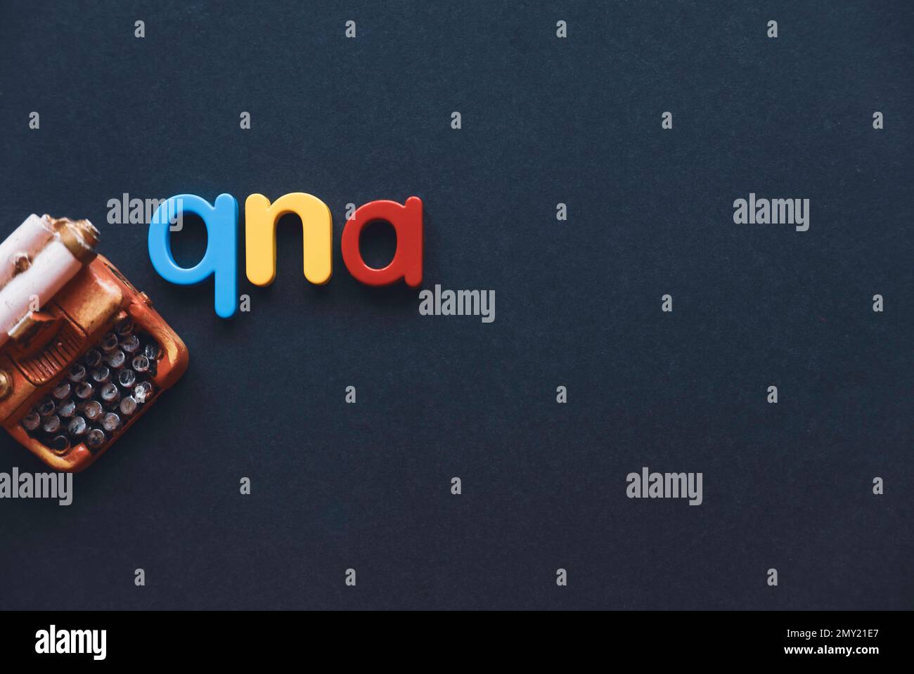 Questions and answers concept. Alphabet qna and miniature typewriter on