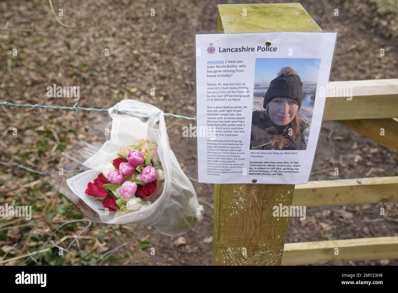 Flowers left by a missing sign in St Michael's on Wyre, Lancashire, as police continue their search for missing woman Nicola Bulley, 45, who was last seen on the morning of Friday January 27, when she was spotted walking her dog on a footpath by the nearby River Wyre. Picture date: Saturday February 4, 2023. Stock Photo