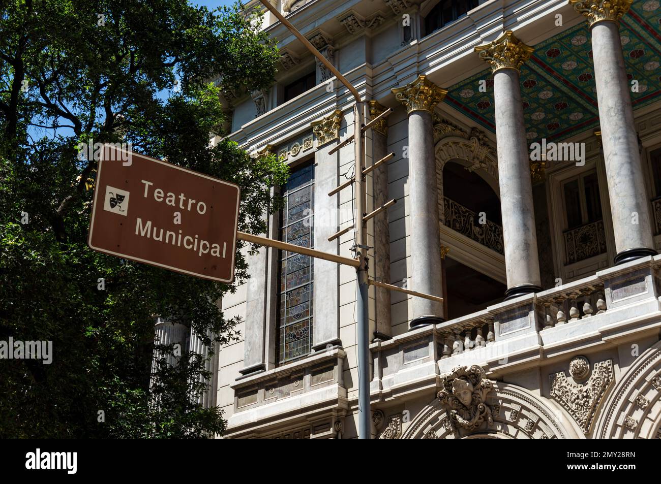 A landmark sign showing the location of Municipal Theater opera house (Theatro Municipal) at Rio Branco avenue in a summer morning sunny blue sky. Stock Photo