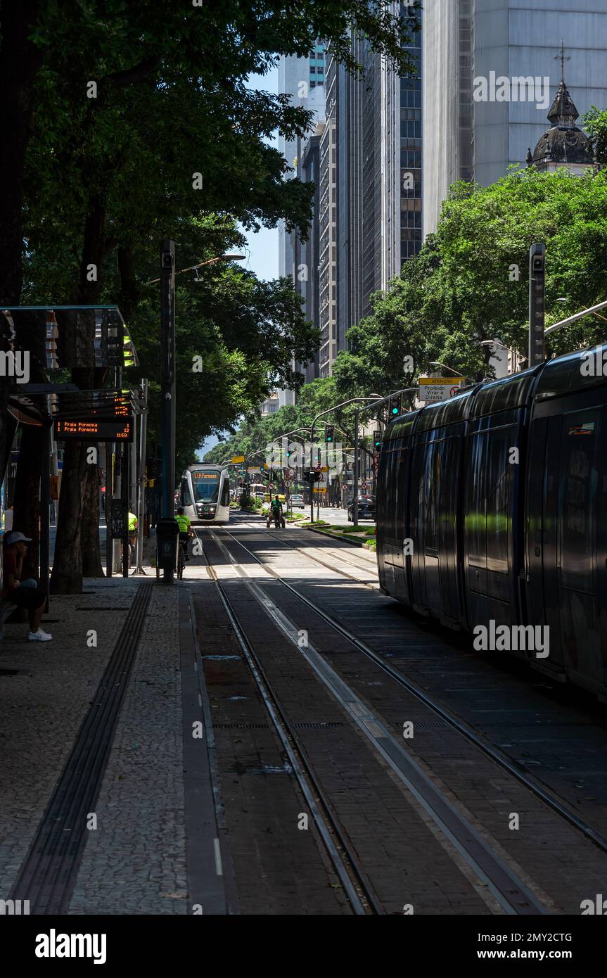 View from Candelaria tram stop of the tram tracks and trams running on Rio Branco avenue in Centro district under summer afternoon clear blue sky. Stock Photo