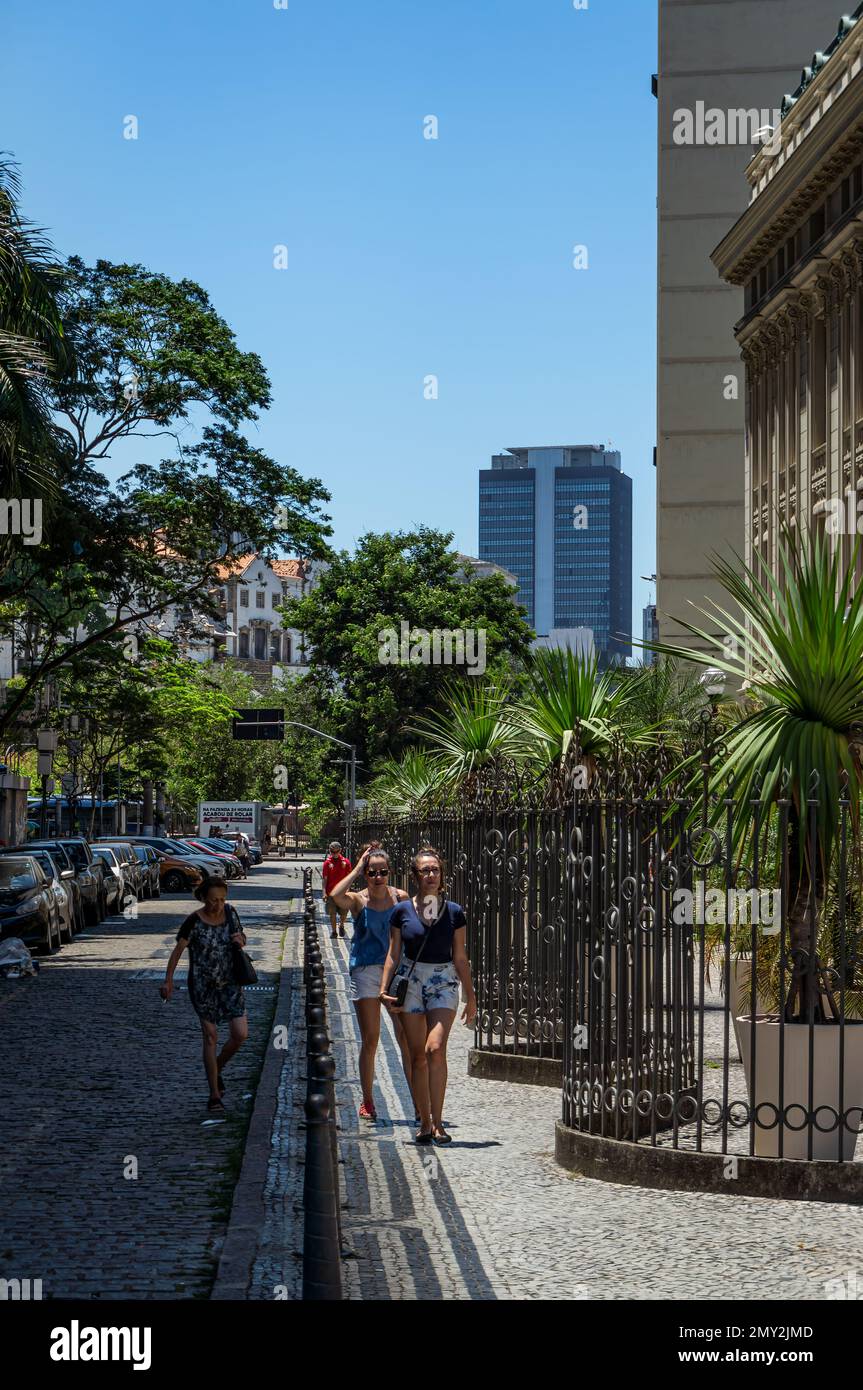 Pedestrians walking on the narrow sidewalk at Municipal Theater (Theatro Municipal) on Treze de Maio avenue under summer afternoon sunny blue sky. Stock Photo