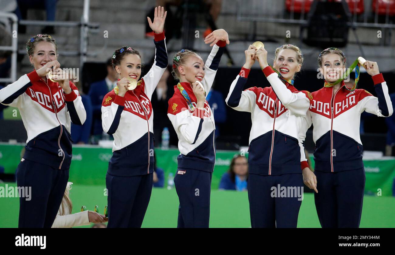 Russian gymnasts display their gold medals for the rhythmic gymnastics ...