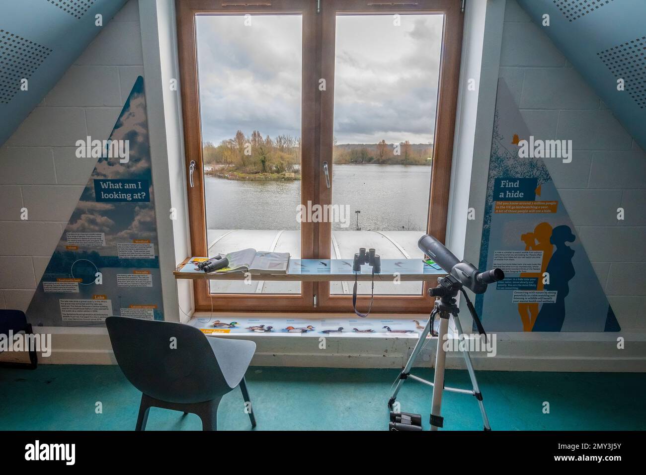 Thatcham Nature Discovery Centre, Berkshire, England, UK, view of the lake from a hide upstairs with telescope and binoculars for bird watching Stock Photo