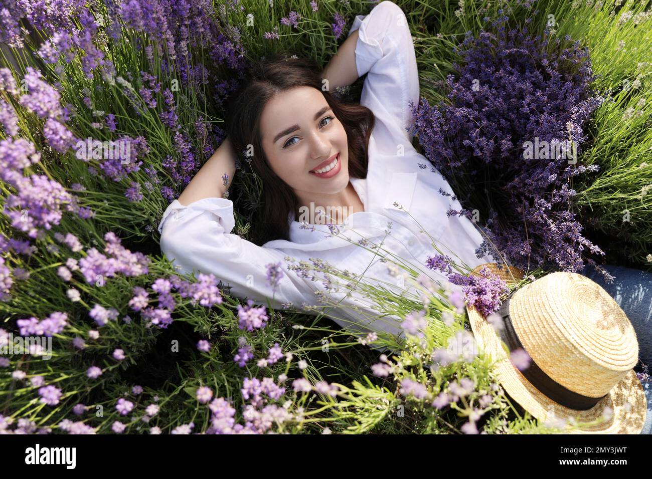 Young woman lying in lavender field on summer day Stock Photo Alamy