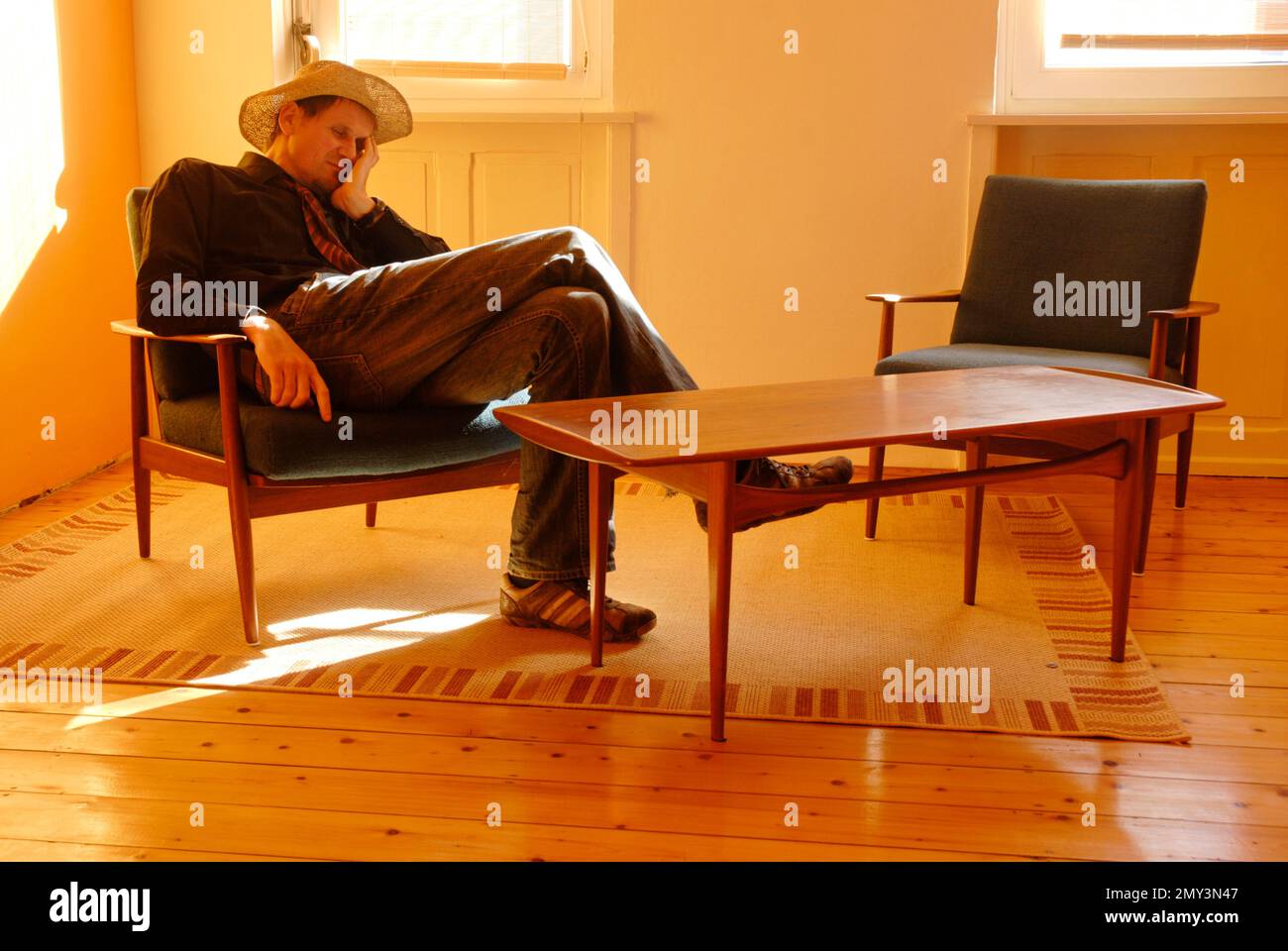 Young man in a straw hat fell asleep on a chair Stock Photo Alamy