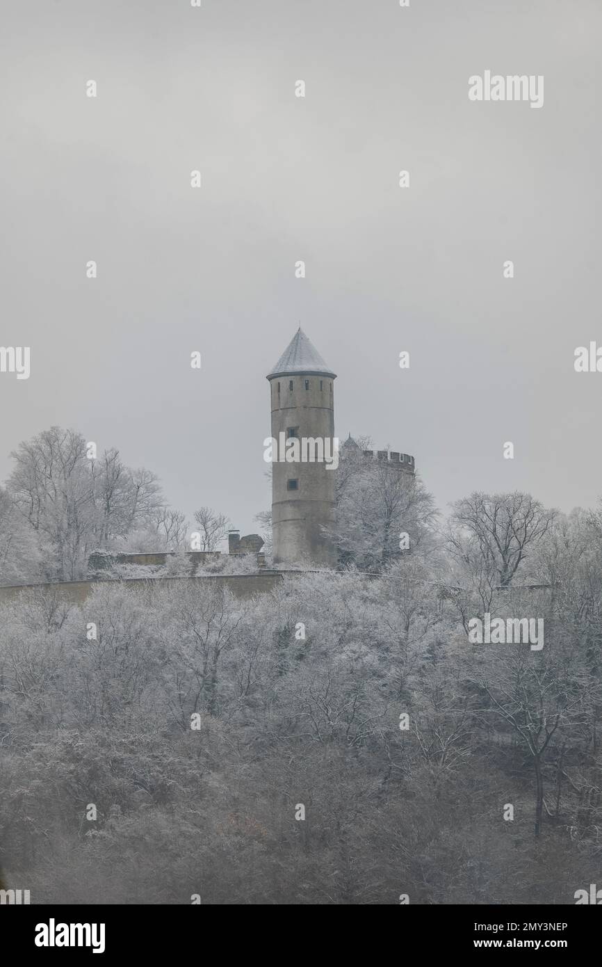 Medieval castle ruins covered with snow on a mountain in winter forest. Plesse castle near Goettingen, Germany Stock Photo