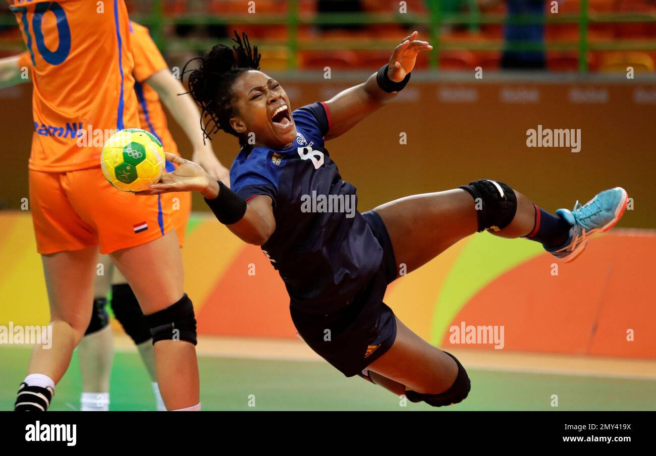France's Laurisa Landre, center, tries to score past Netherlands' Danick  Snelder, left, during the women's semifinal handball match between France  and Netherlands at the 2016 Summer Olympics in Rio de Janeiro, Brazil,