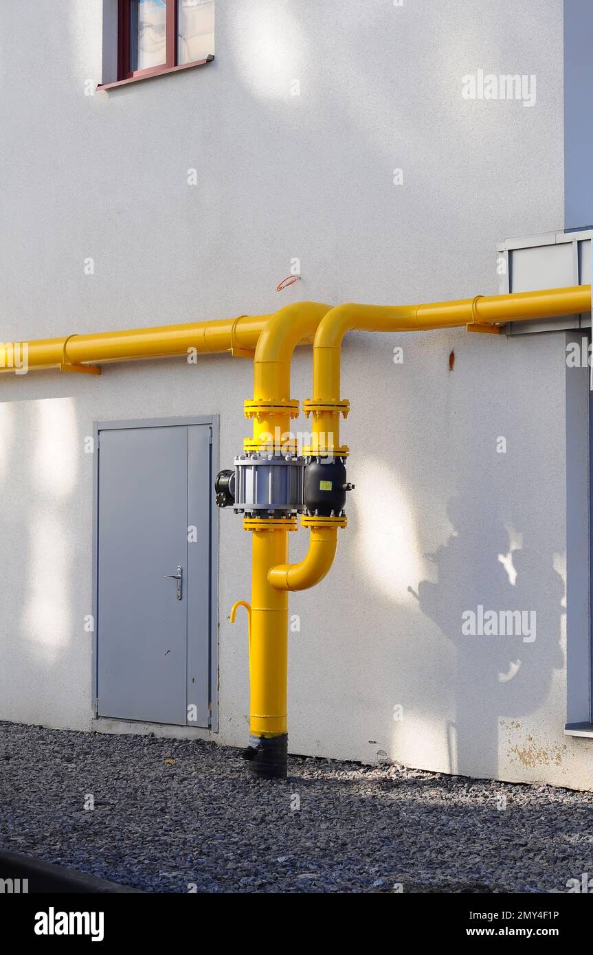 Yellow gas pipe near the wall of an apartment building. Connecting the