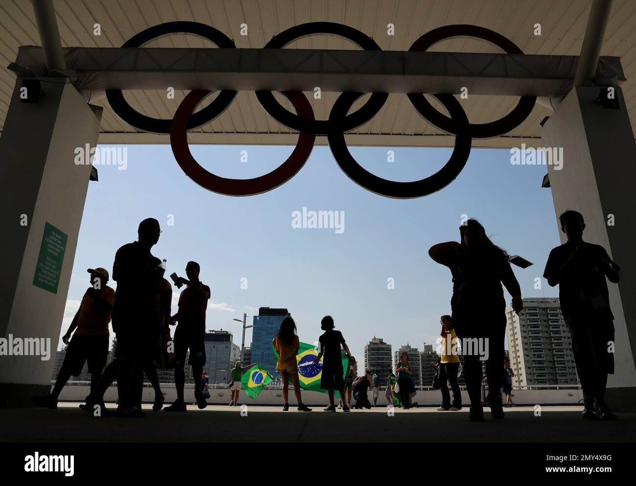 Fans walk to their seats under a set of Olympic rings before the ...