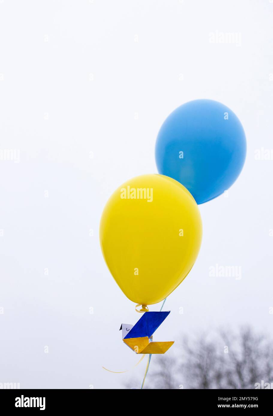 paper dove of peace, flies into the sky on two yellow-blue balloons of the Ukrainian flag. Support Ukraine. Stop the war. Symbol of peace and faith in Stock Photo