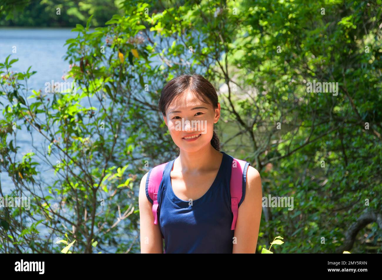 a chinese woman posing in nature with a sunny background outdoors at burr pond in torrington, connecticut. Stock Photo