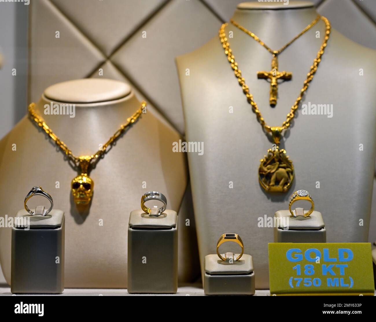 Custom rings on display with gold jewellery behind Stock Photo Alamy
