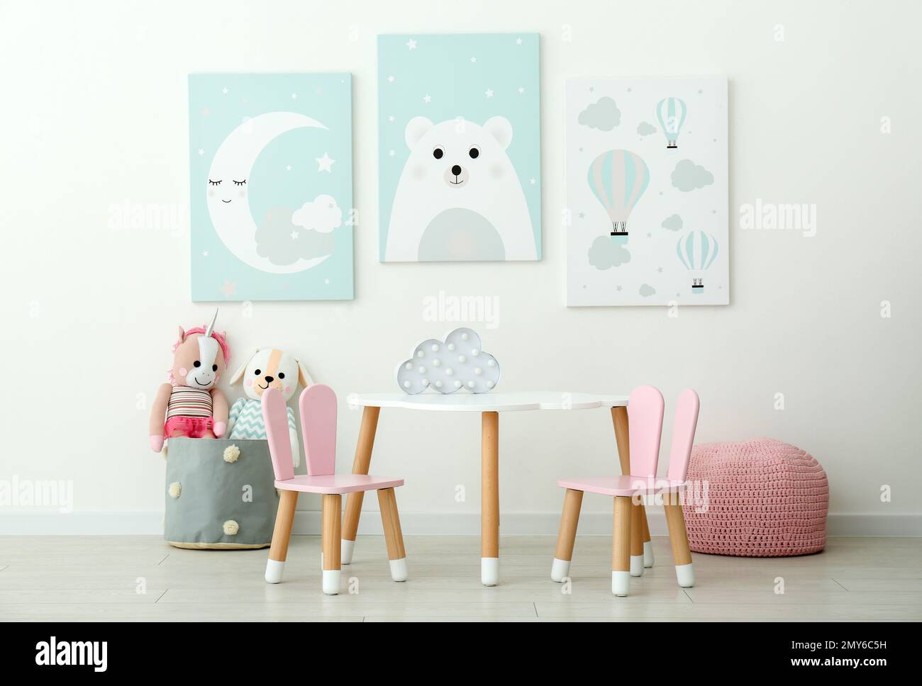 Adorable wall art, table and chairs with bunny ears in children's room interior Stock Photo Alamy