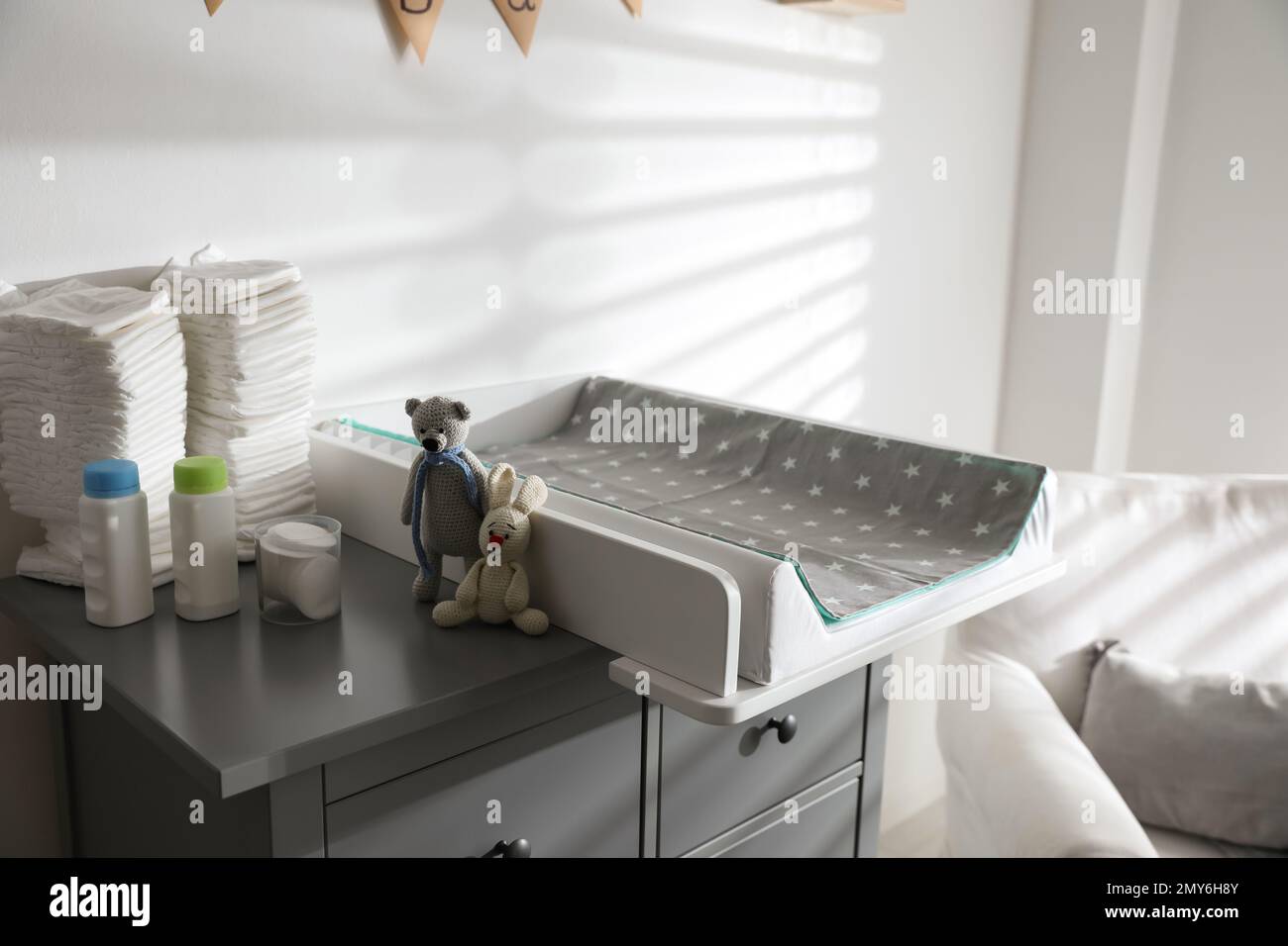 Chest of drawers with changing tray and pad in baby room. Interior