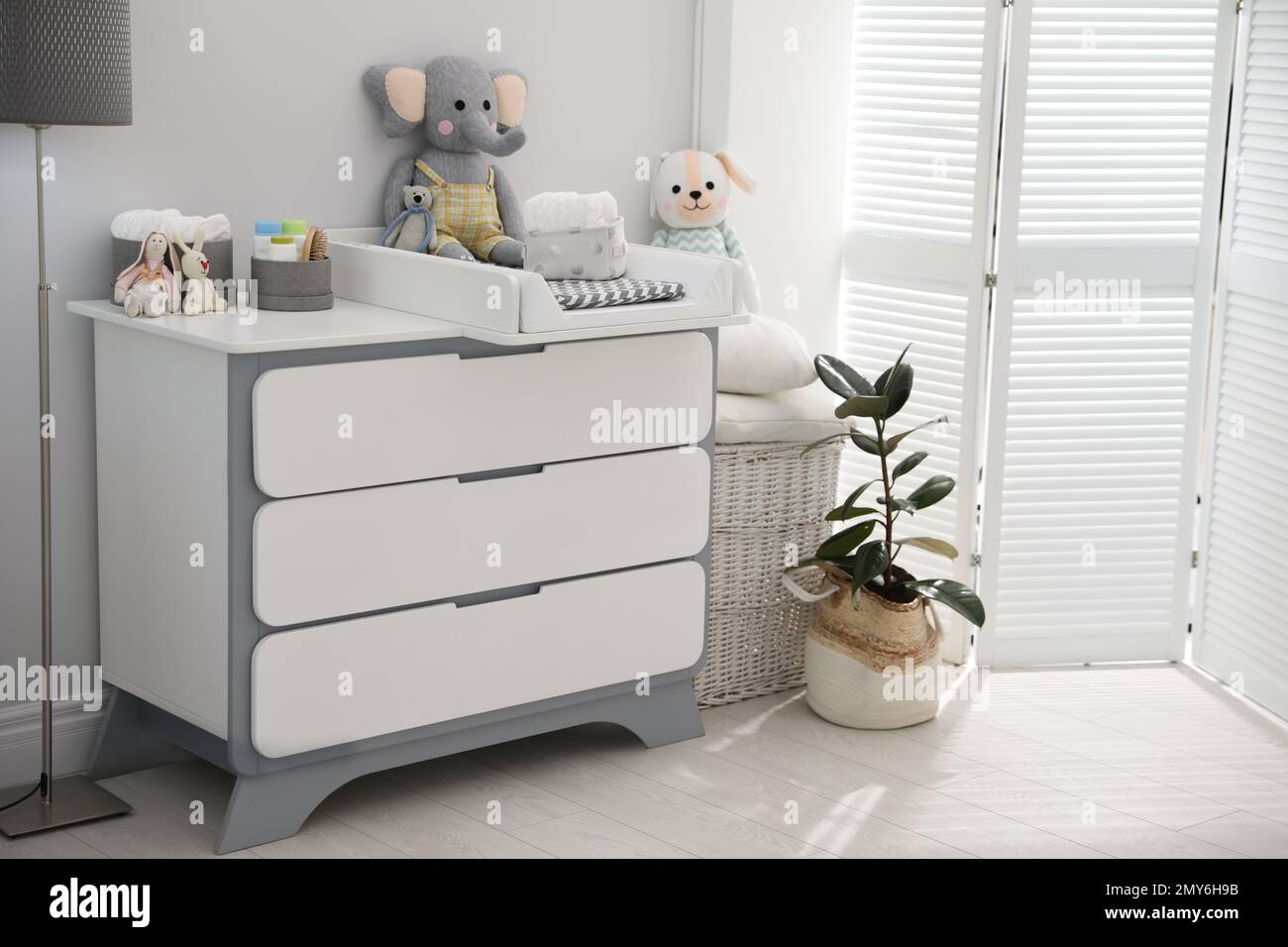Changing tray and pad on chest of drawers in baby room. Interior design