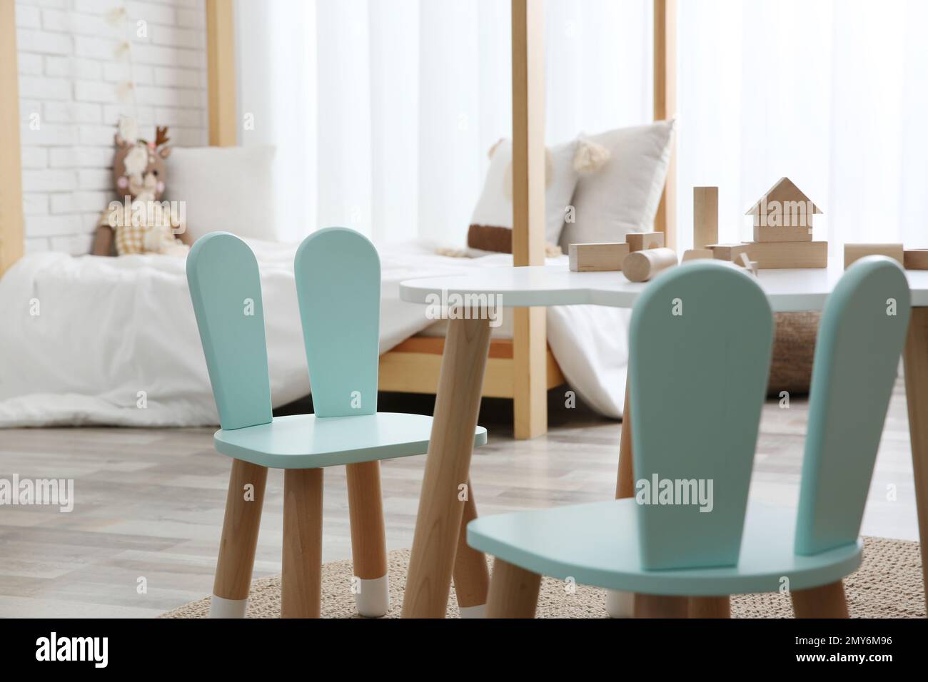 Little table and chairs with bunny ears in children's room. Interior