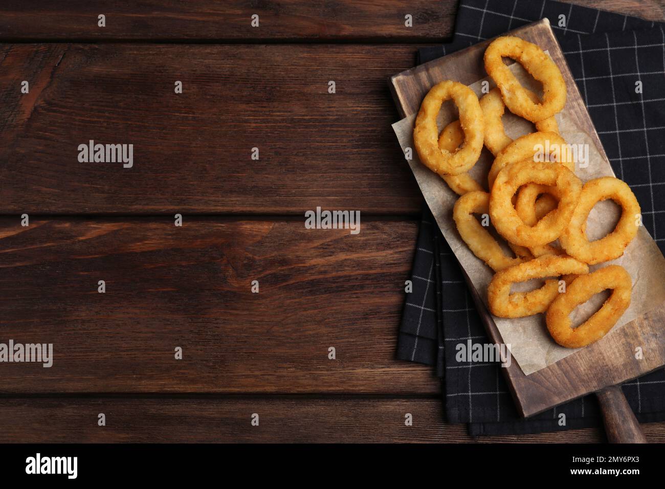 Fried onion rings served on wooden table, top view. Space for text Stock Photo