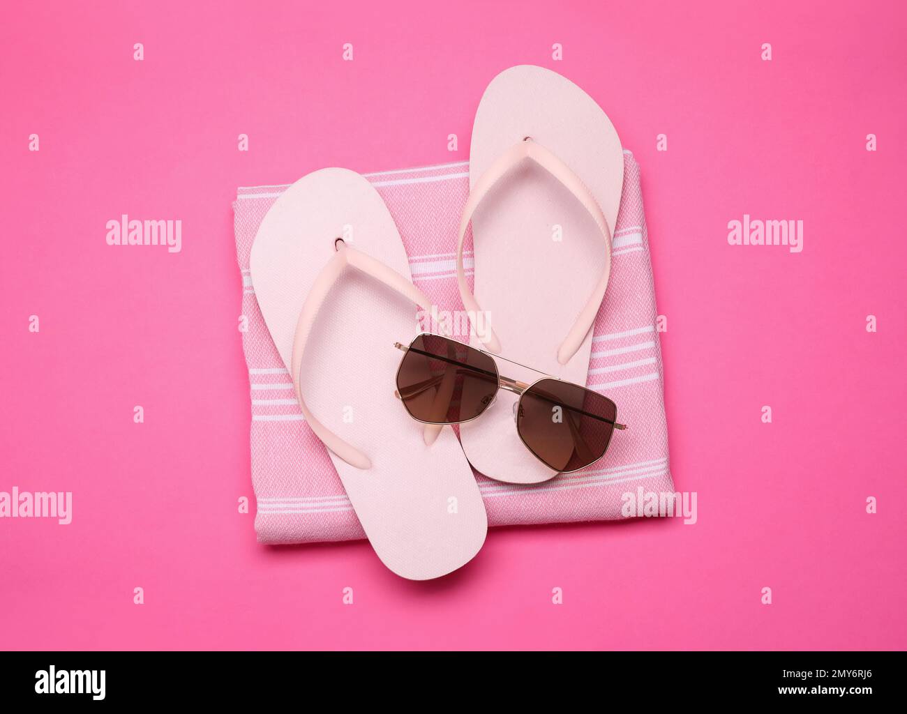 Towel, flip flops and sunglasses on pink background, top view. Beach ...