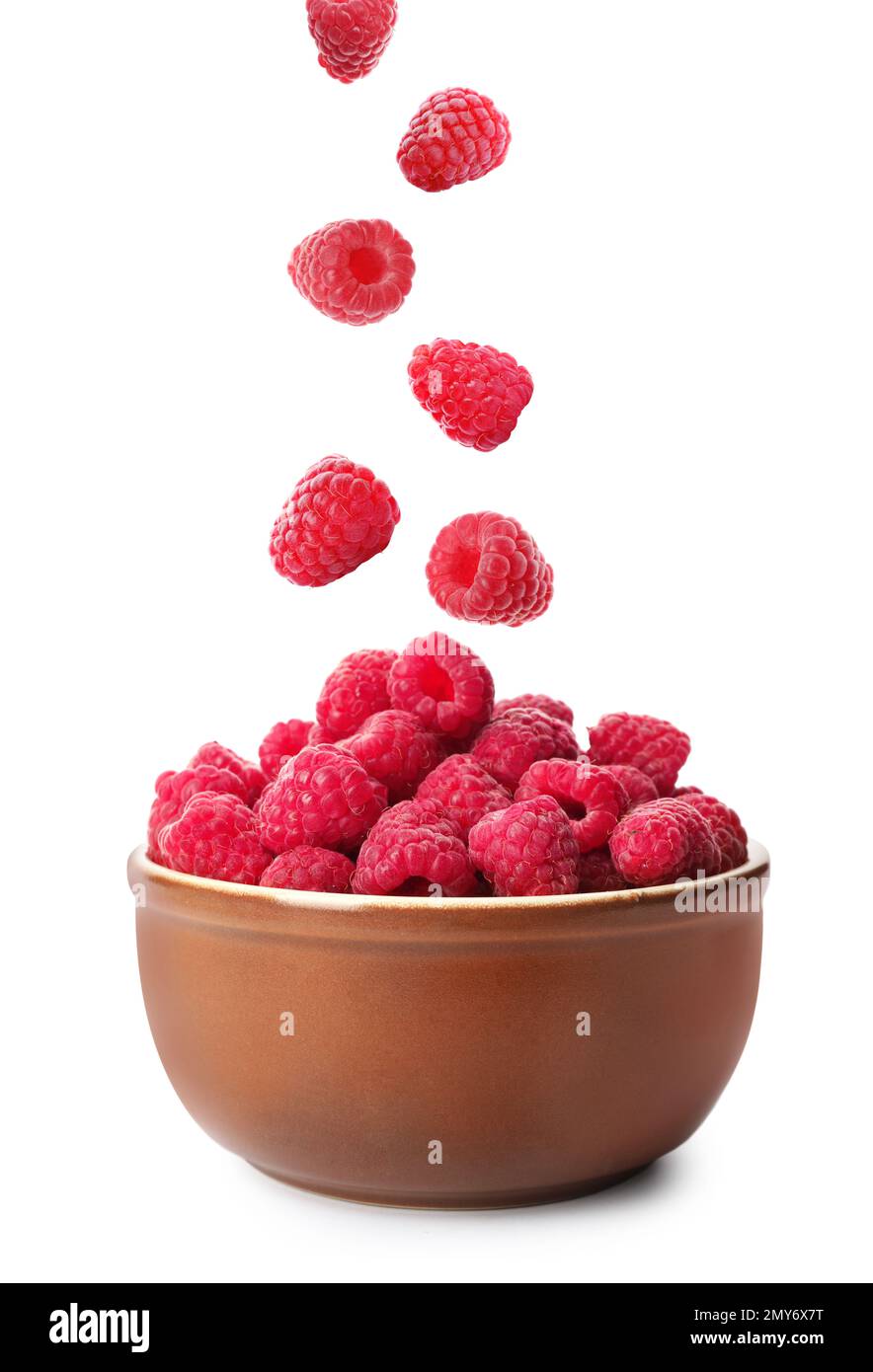 Fresh ripe raspberries falling into bowl on white background Stock ...
