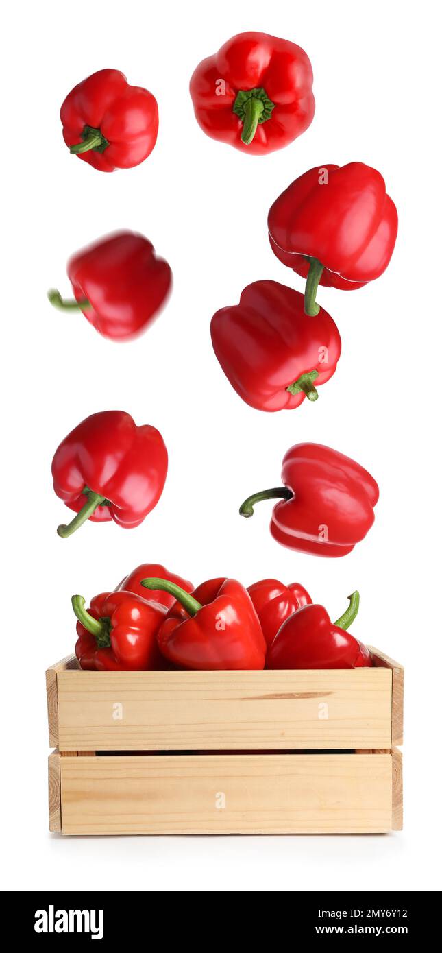 Red bell peppers falling into wooden crate on white background Stock ...