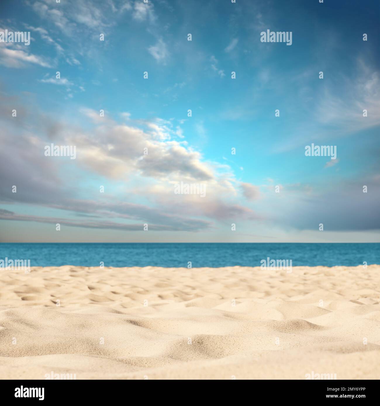 Sandy beach near sea under blue sky with clouds Stock Photo - Alamy