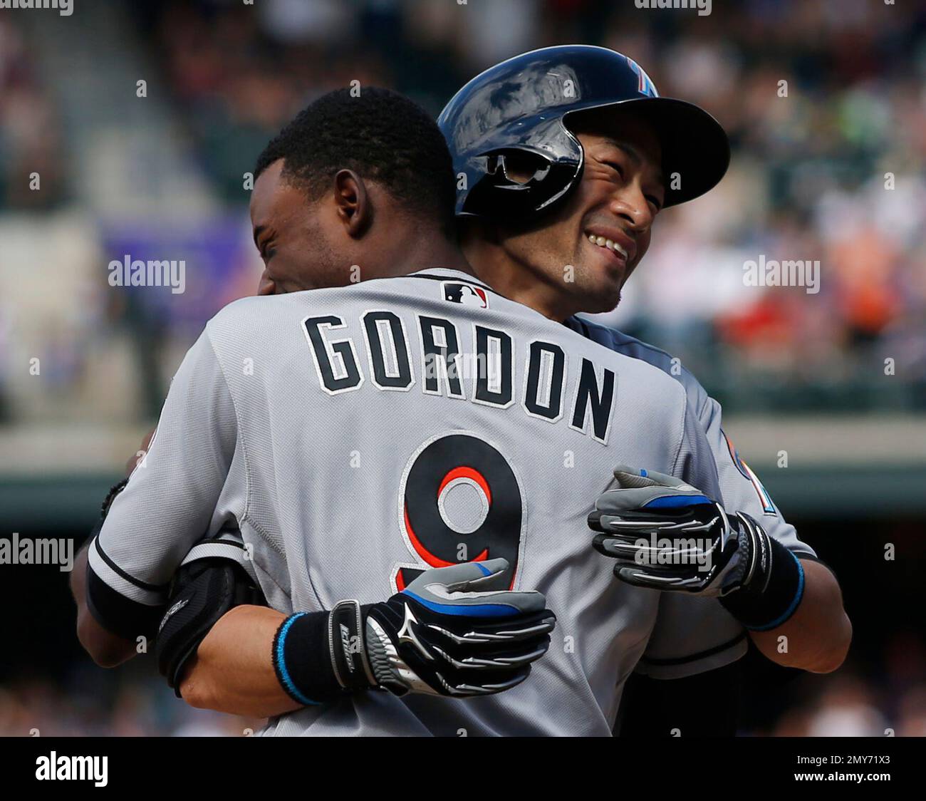 Miami Marlins' Ichiro Suzuki hugs a teammate after recording in the 7th  inning of the game against the Colorado Rockies to get his 3,000th career  hit in the major leagues at Coors