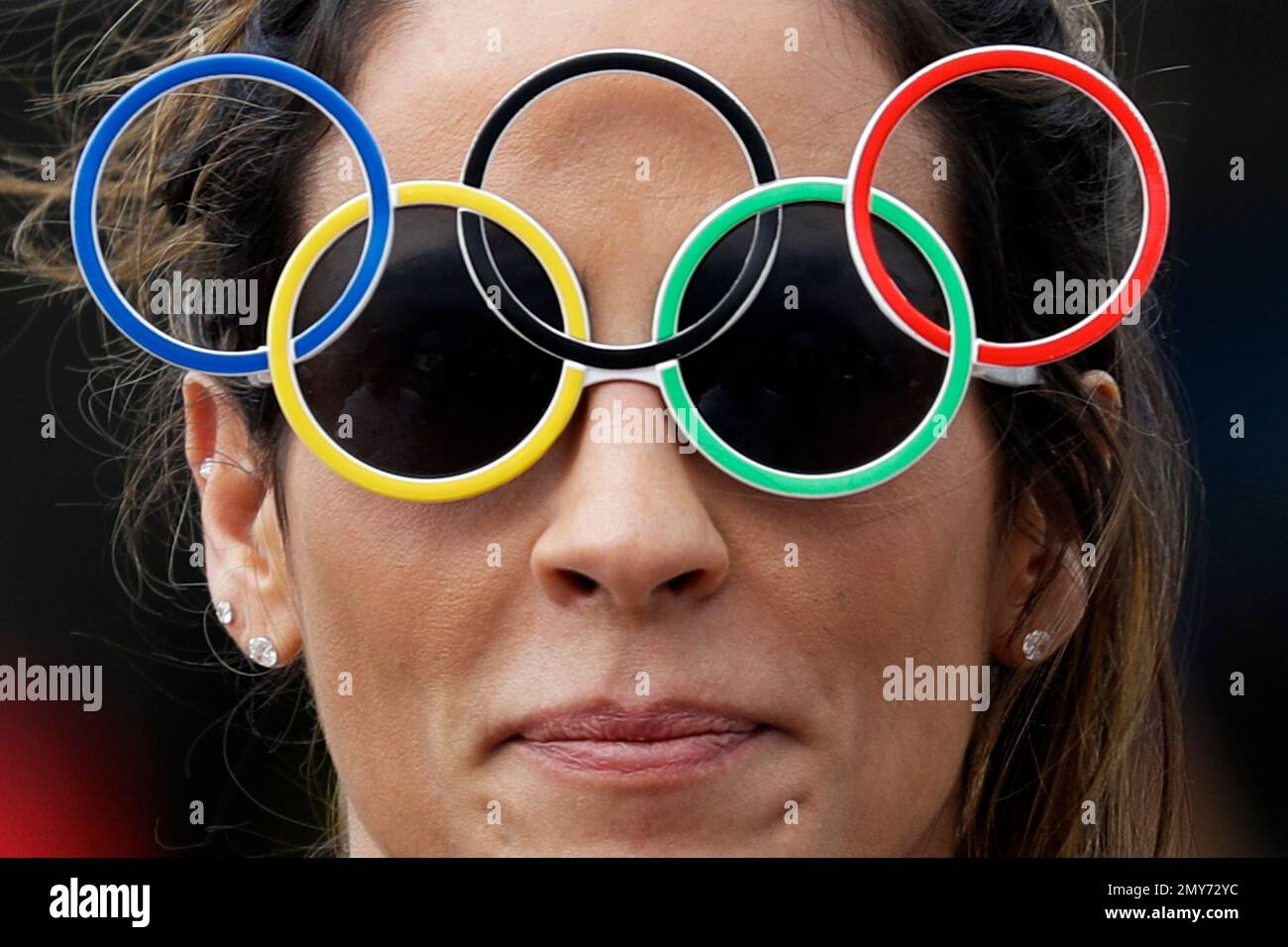 A woman wearing Olympic rings glasses smiles as she walks in Olympic Park  at the 2016 Summer Olympics in Rio de Janeiro, Brazil, Monday, Aug. 8,  2016. (AP Photo/Pavel Golovkin Stock Photo - Alamy