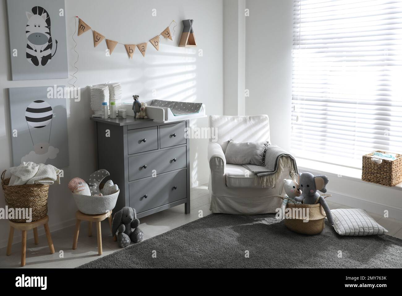 Chest of drawers with changing tray and pad in baby room. Interior