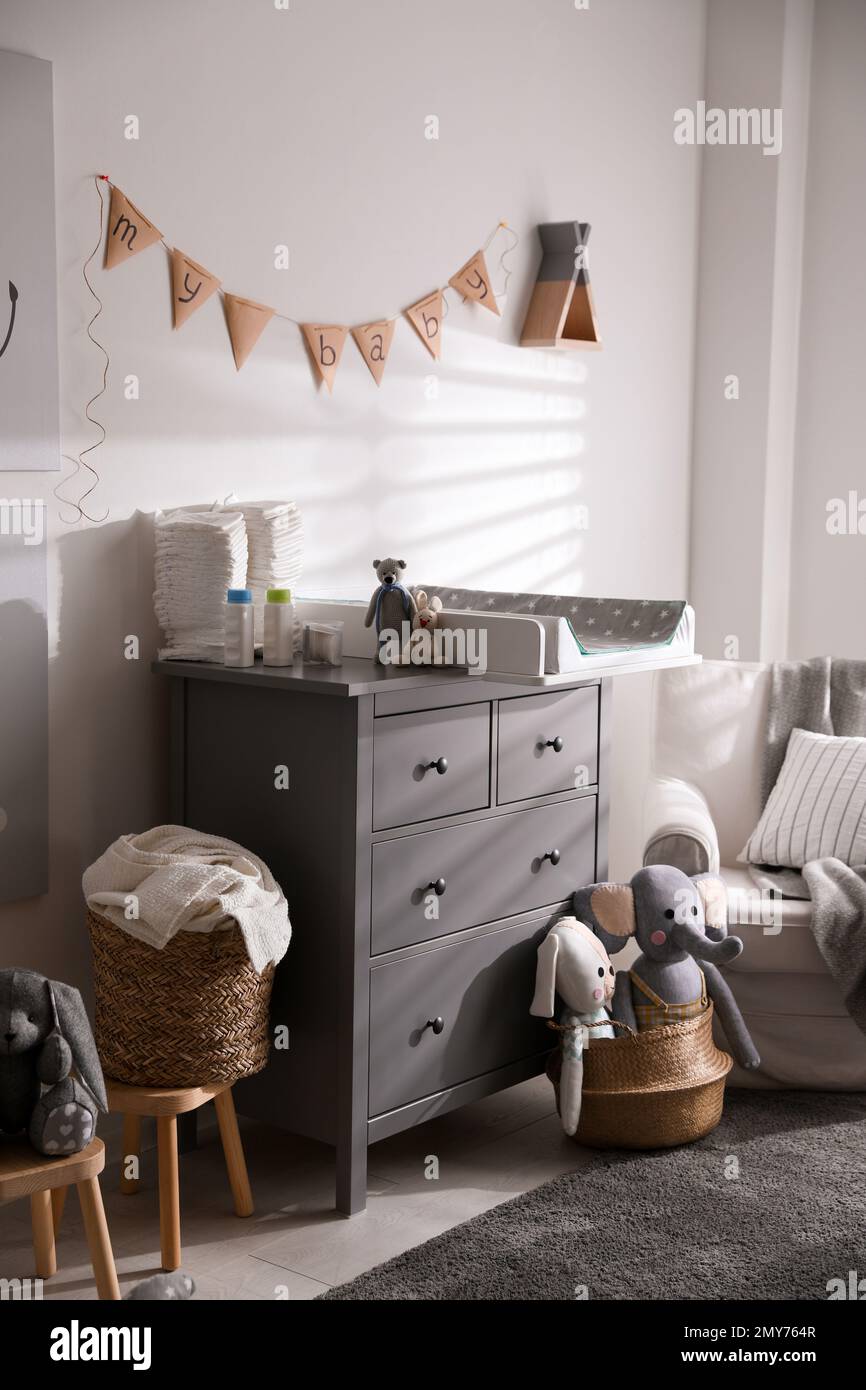 Chest of drawers with changing tray and pad in baby room. Interior