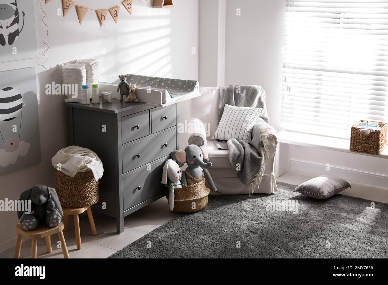 Chest of drawers with changing tray and pad in baby room. Interior