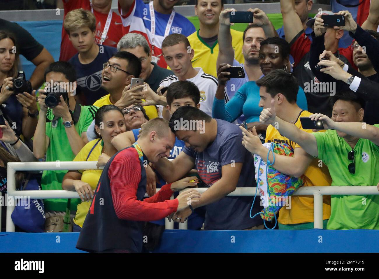 Caeleb Dressel from the United States is greeted by a fan after winning ...