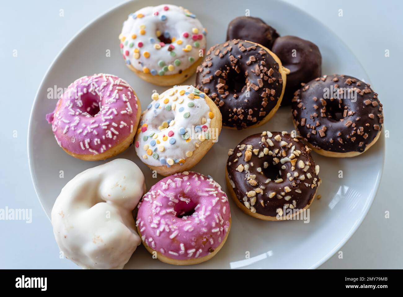 Assorted ring doughnuts covered in icing and sprinkles Stock Photo Alamy