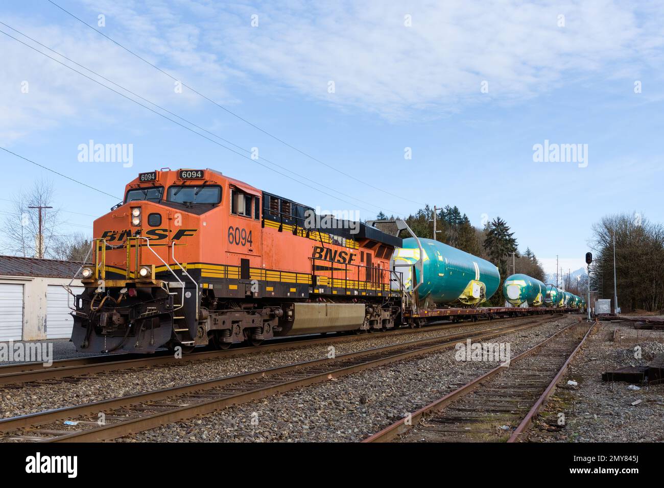 Monroe, WA, USA - February 1, 2023; BNSF locomotive hauling freight train of Boeing 737 fuselages in green protective coating Stock Photo