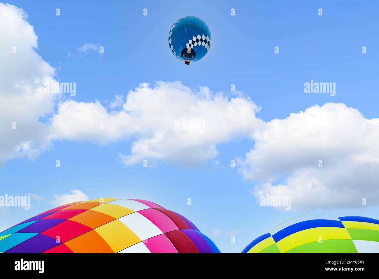 Colorful hot air balloon flying over blue sky Stock Photo - Alamy