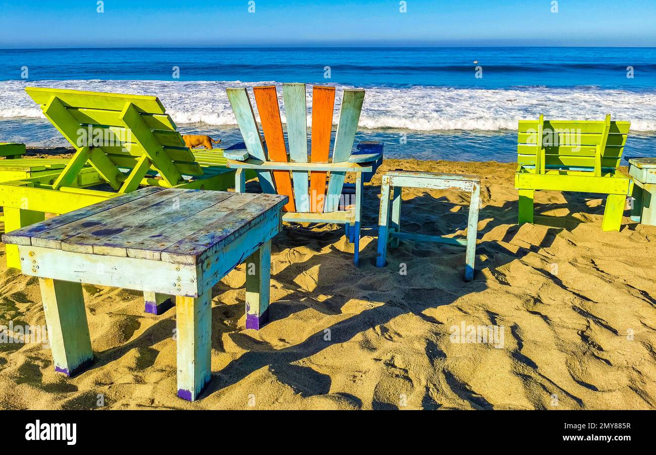 Parasols umbrellas sun loungers palms people rocks and waves at the