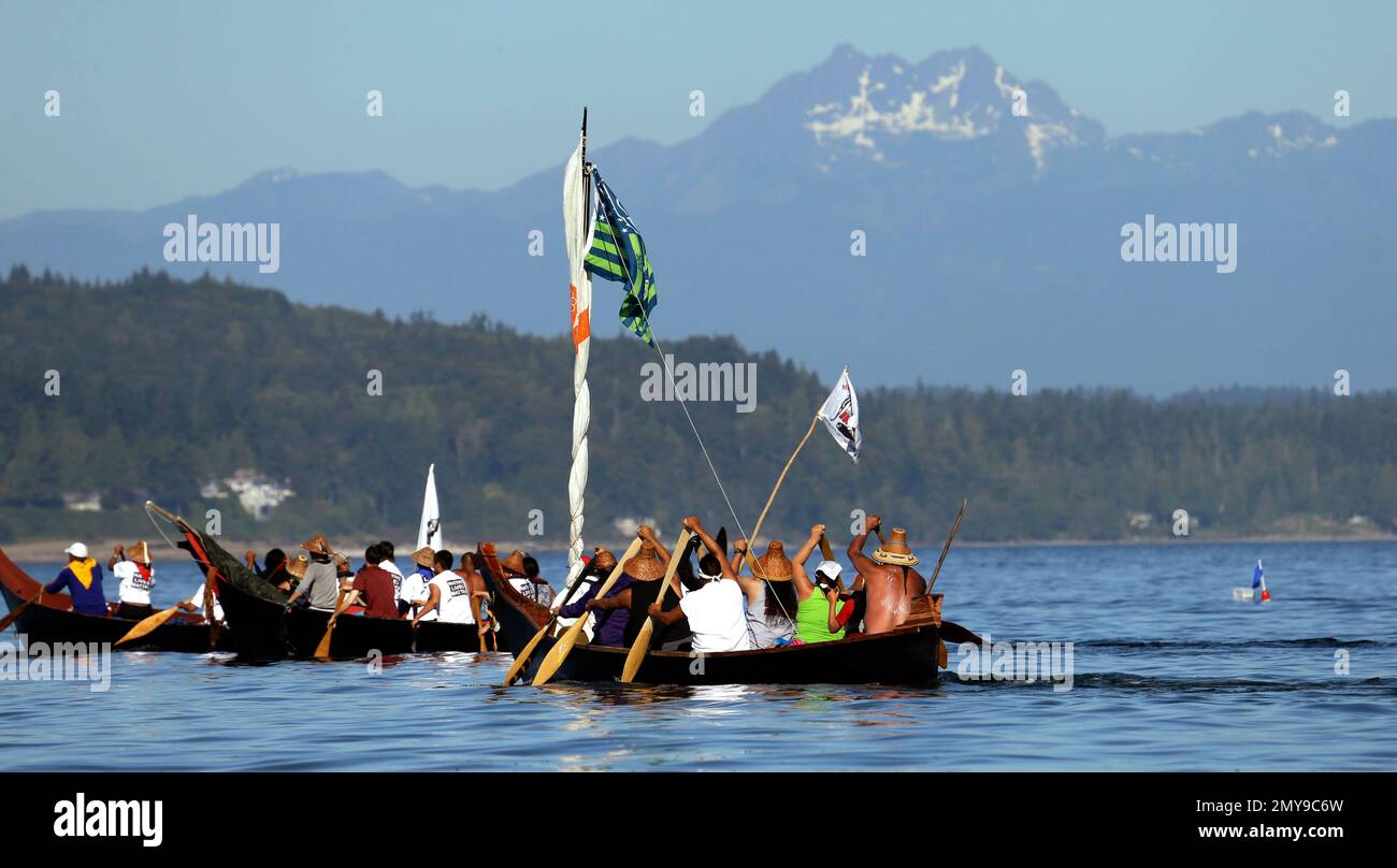 Native Racing Canoe Tribal canoes are paddled in view of the Olympic mountains after ...