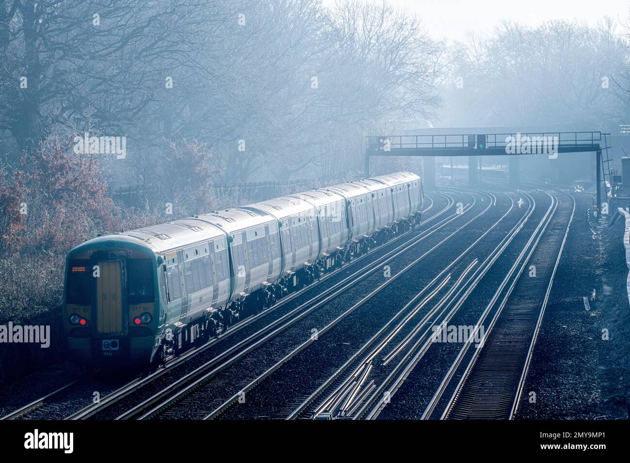 A foggy, frosty day and a train heads to Victoria station in London, England Stock Photo