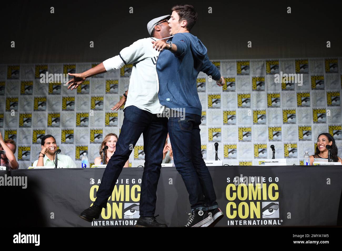 Jesse L. Martin, left, and Grant Gustin chest-bump as they tap 