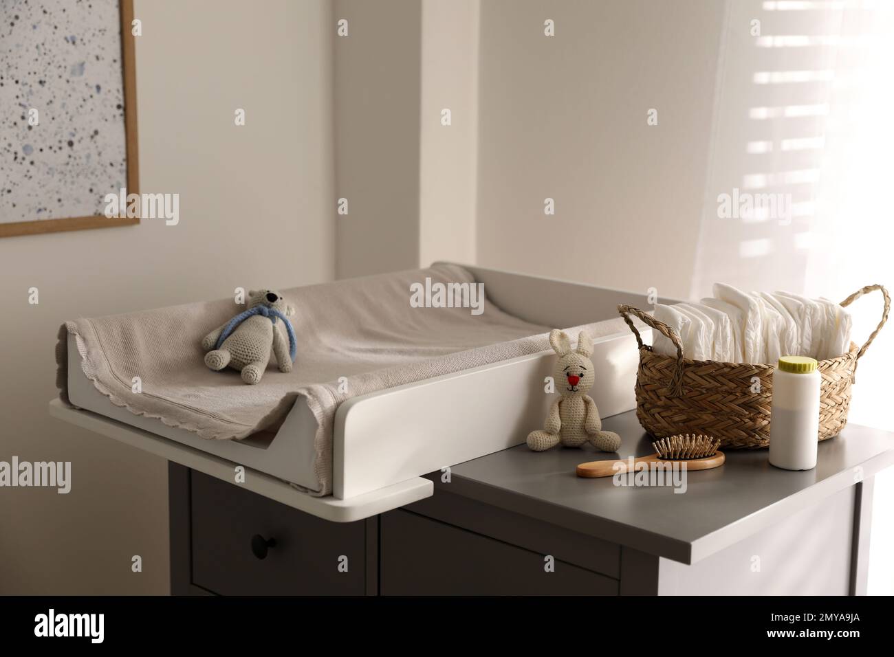 Chest of drawers with changing pad and tray in nursery. Baby room