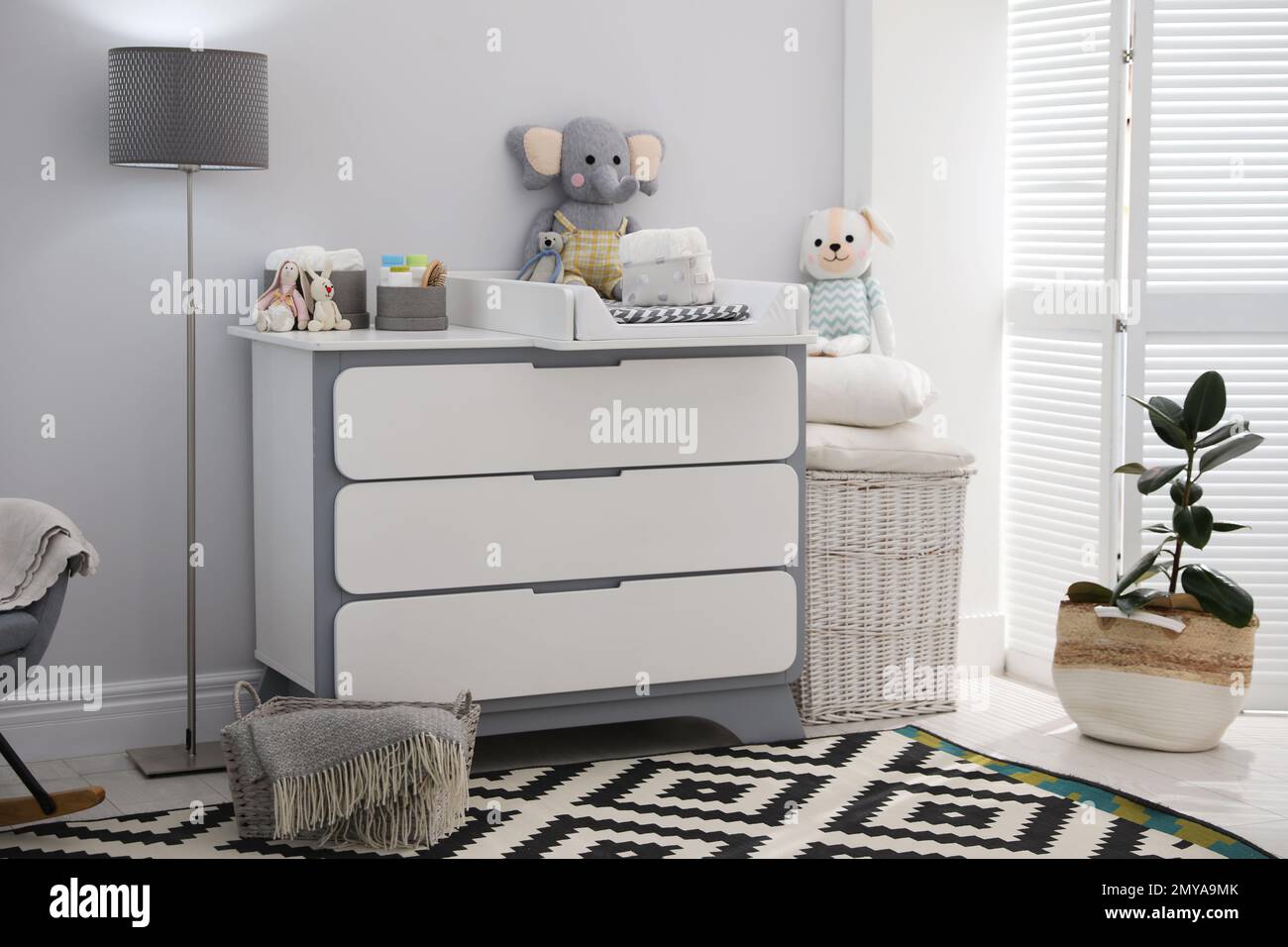 Changing tray and pad on chest of drawers in baby room. Interior design