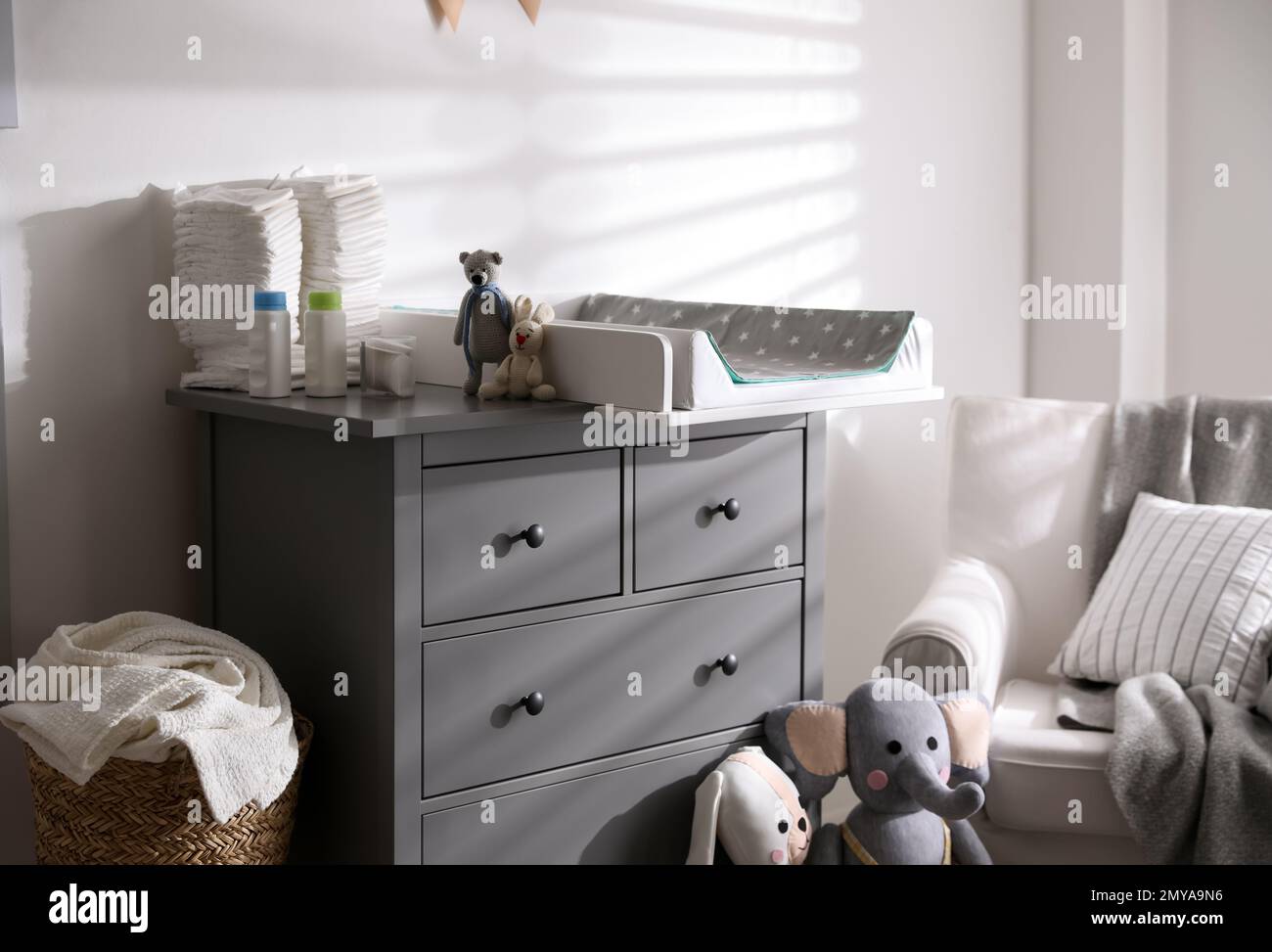 Chest of drawers with changing tray and pad in baby room. Interior