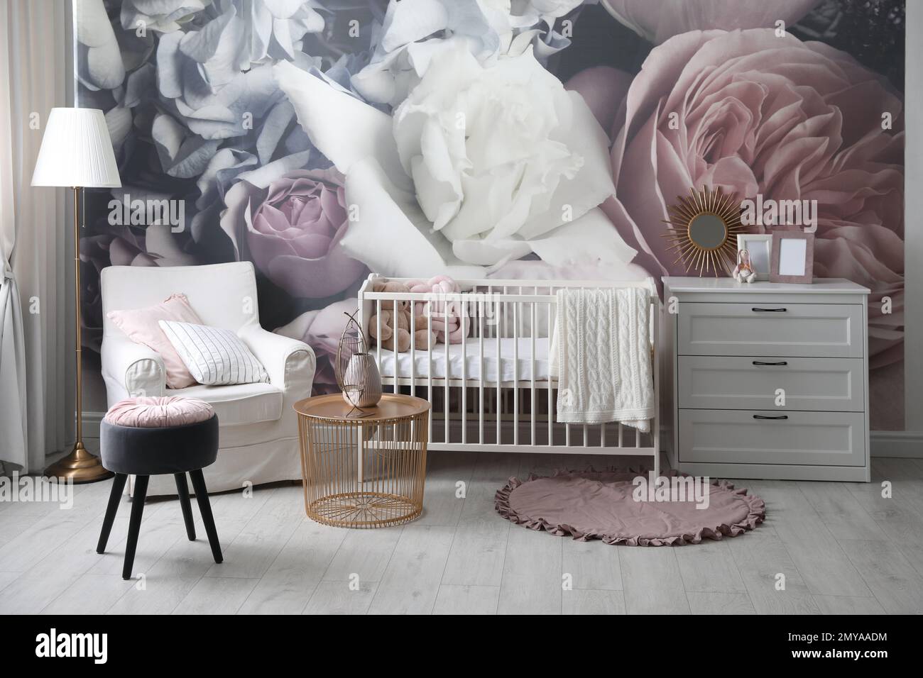 Baby room interior with stylish crib and floral wallpaper Stock Photo