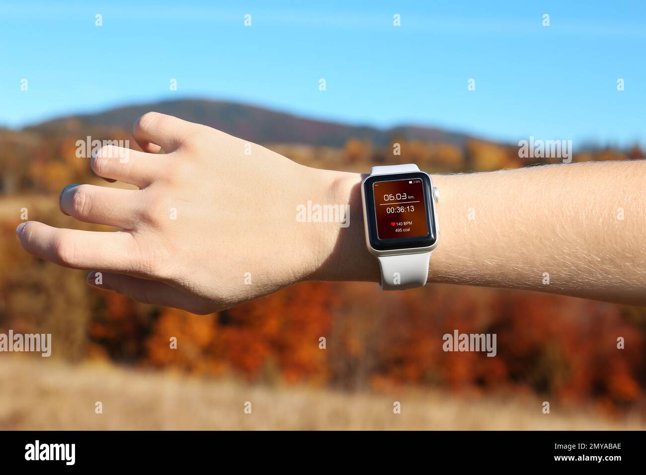 Woman with smart watch checking time interval, distance, heart rate and