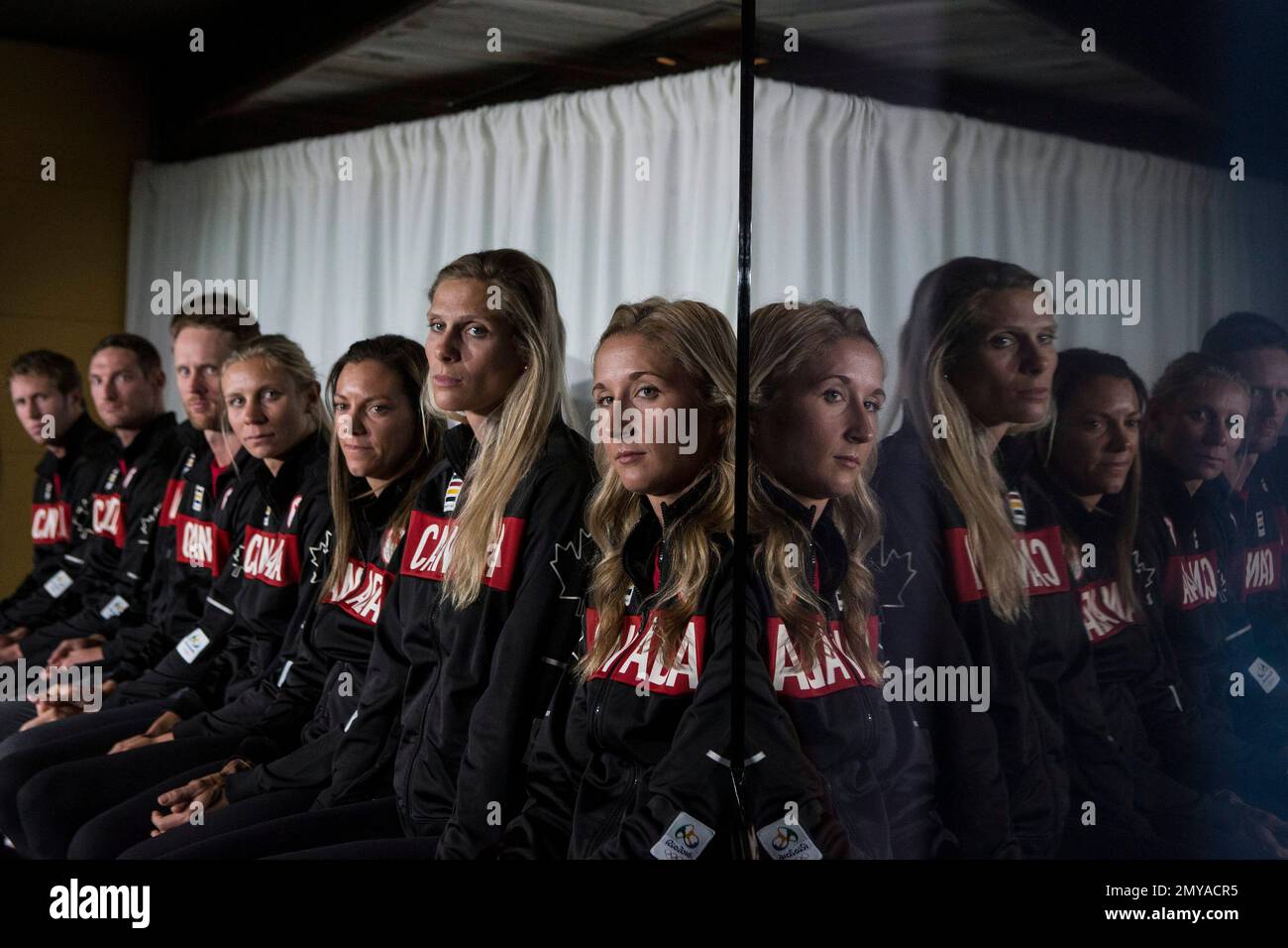 Members of the four teams to represent Canada in Beach Volleyball at the  Rio 2016 Olympic Games are pictured sitting next to a monitor at the  Canadian Olympic Committee's press availability for