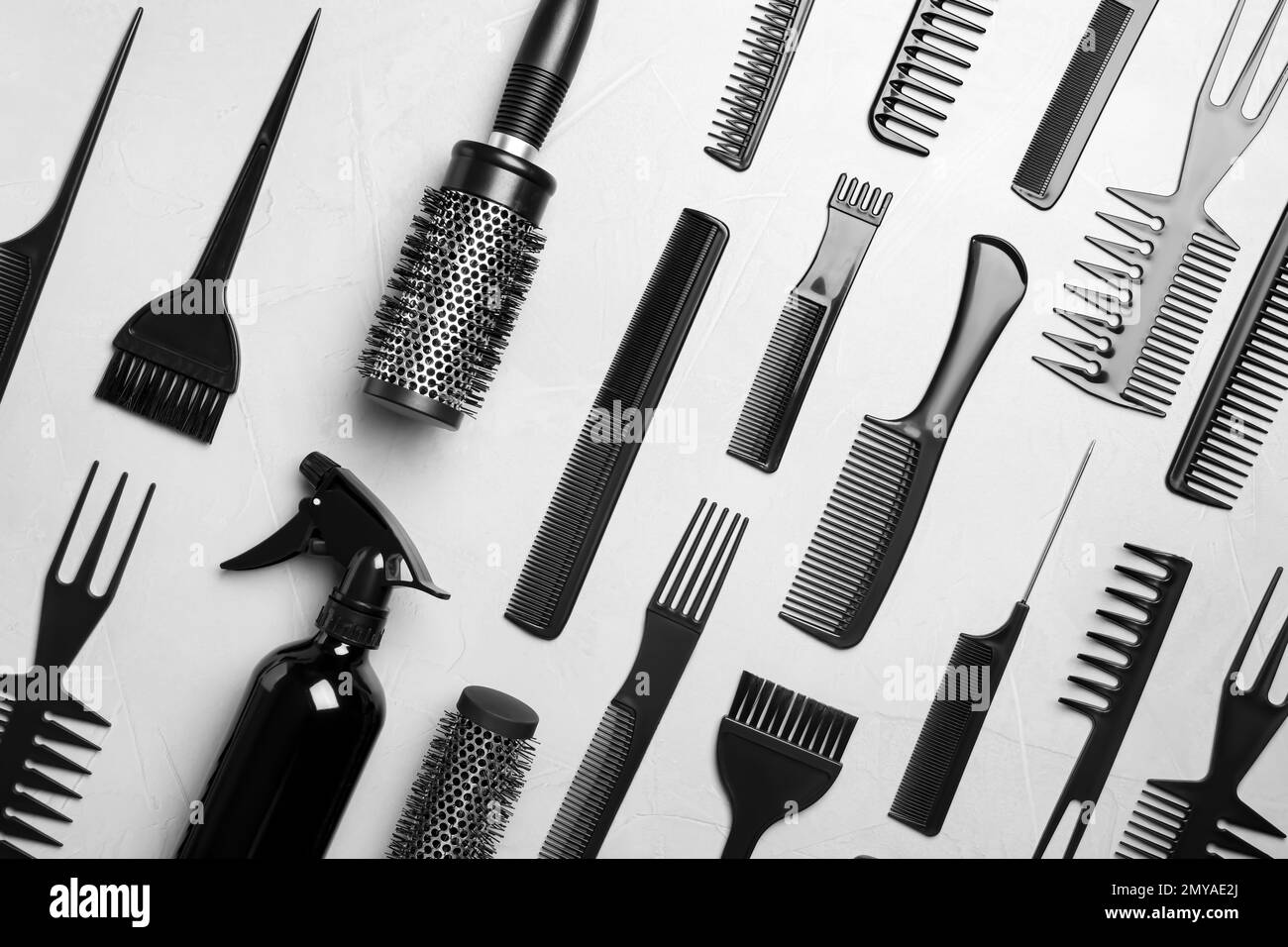Flat lay composition with hair brushes and combs on light grey stone ...