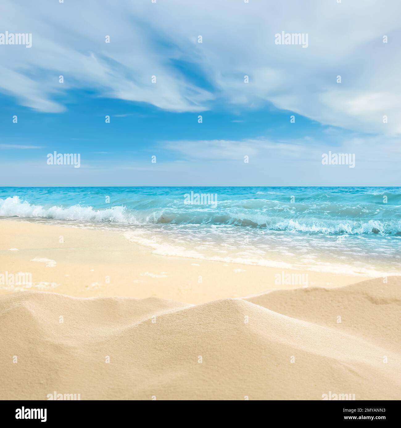 Ocean waves rolling on sandy beach under blue sky with clouds Stock ...