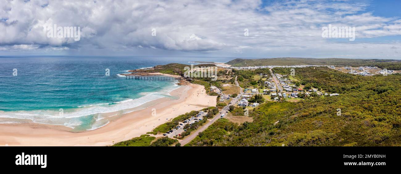Aerial panorama of Catherine Hill bay beach waterfront with historic pier jetty and wide sandy