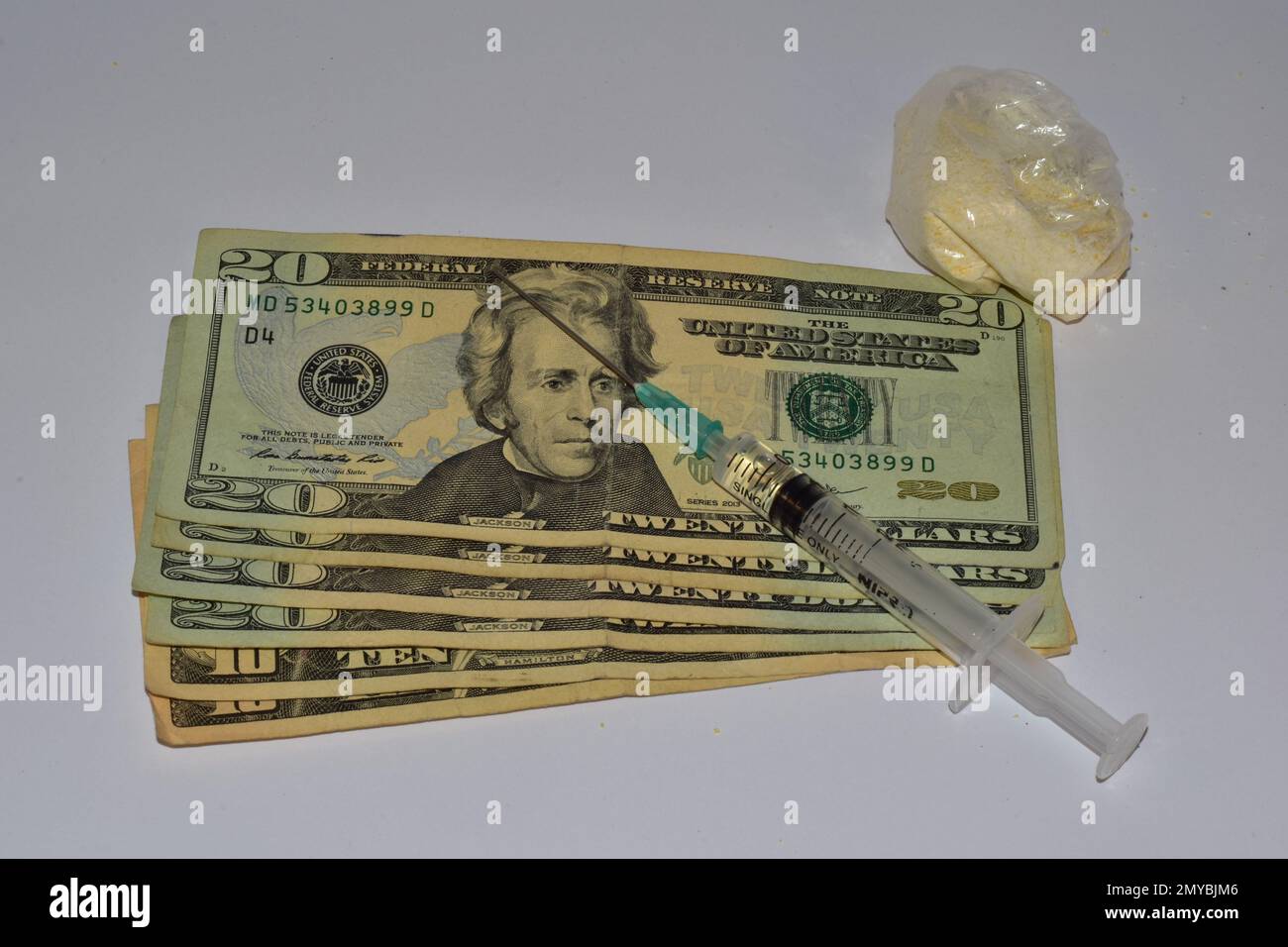 20 dollar bills with syringe and pills on a white background Stock Photo