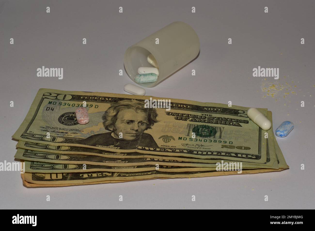 20 dollar bills with syringe and pills on a white background Stock Photo