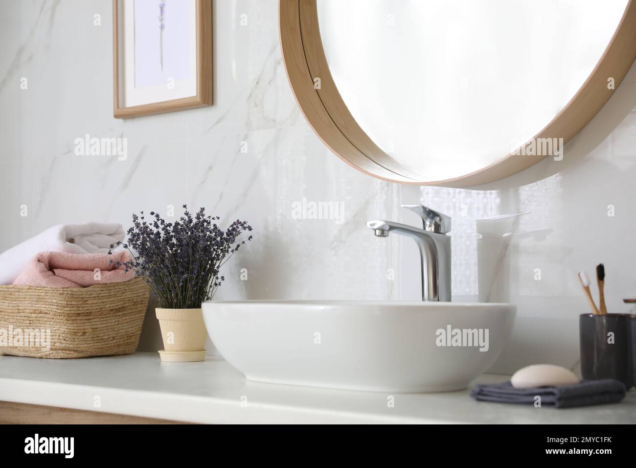 Bathroom counter with vessel sink, flowers and towels in bathroom